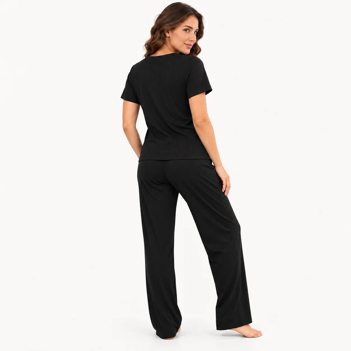 Vista trasera de pijama para mujer color negro, conjunto de tela rib acanalada con camiseta de manga corta y pantalón largo de corte recto.